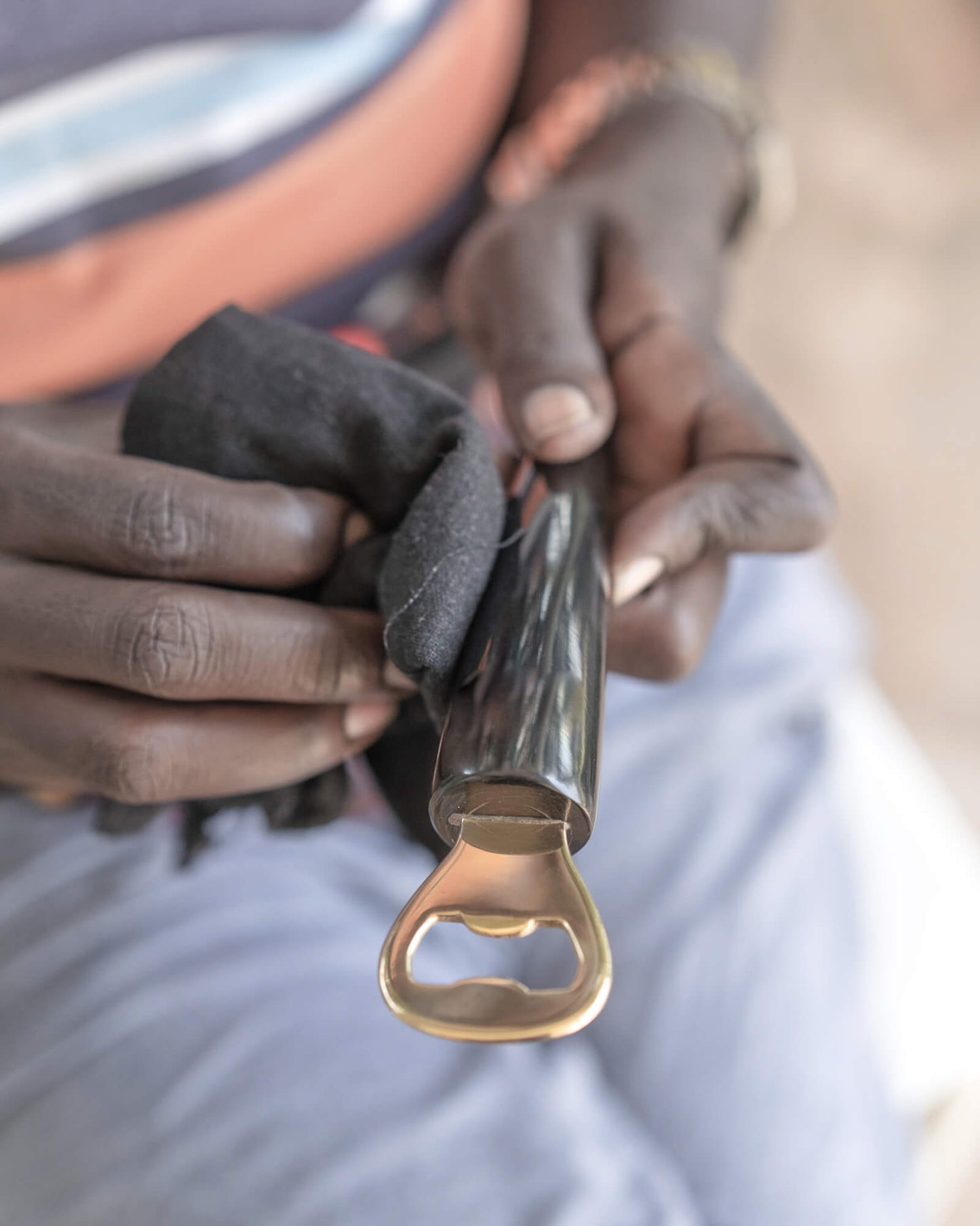 
                  
                    Ugandan artisan hand-polishing Ankole horn and brass bottle opener Fairkind ethically sourced and handmade in Uganda.
                  
                
