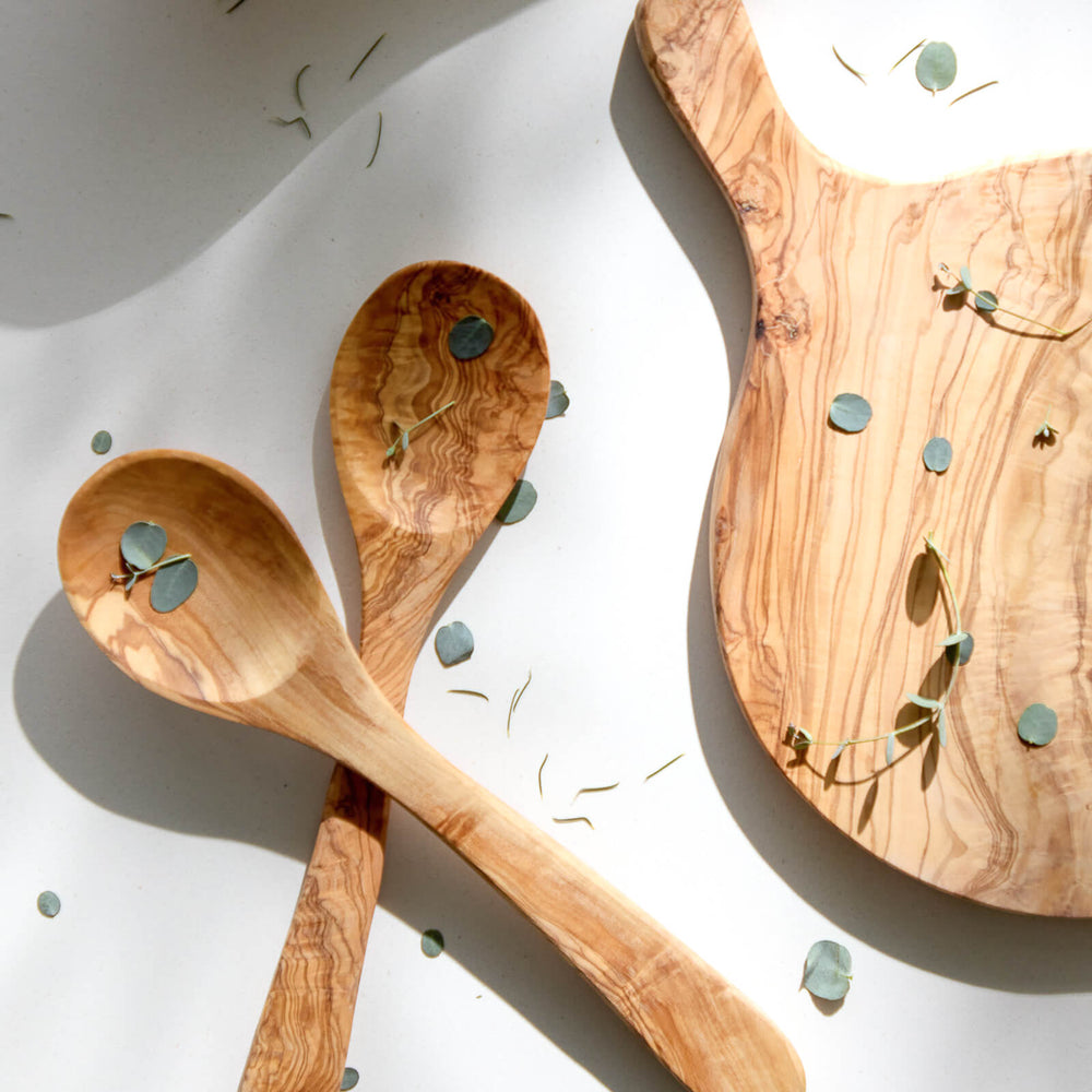 
                  
                    Olive wood spoons and bread board with shadows cast and loose florals.
                  
                