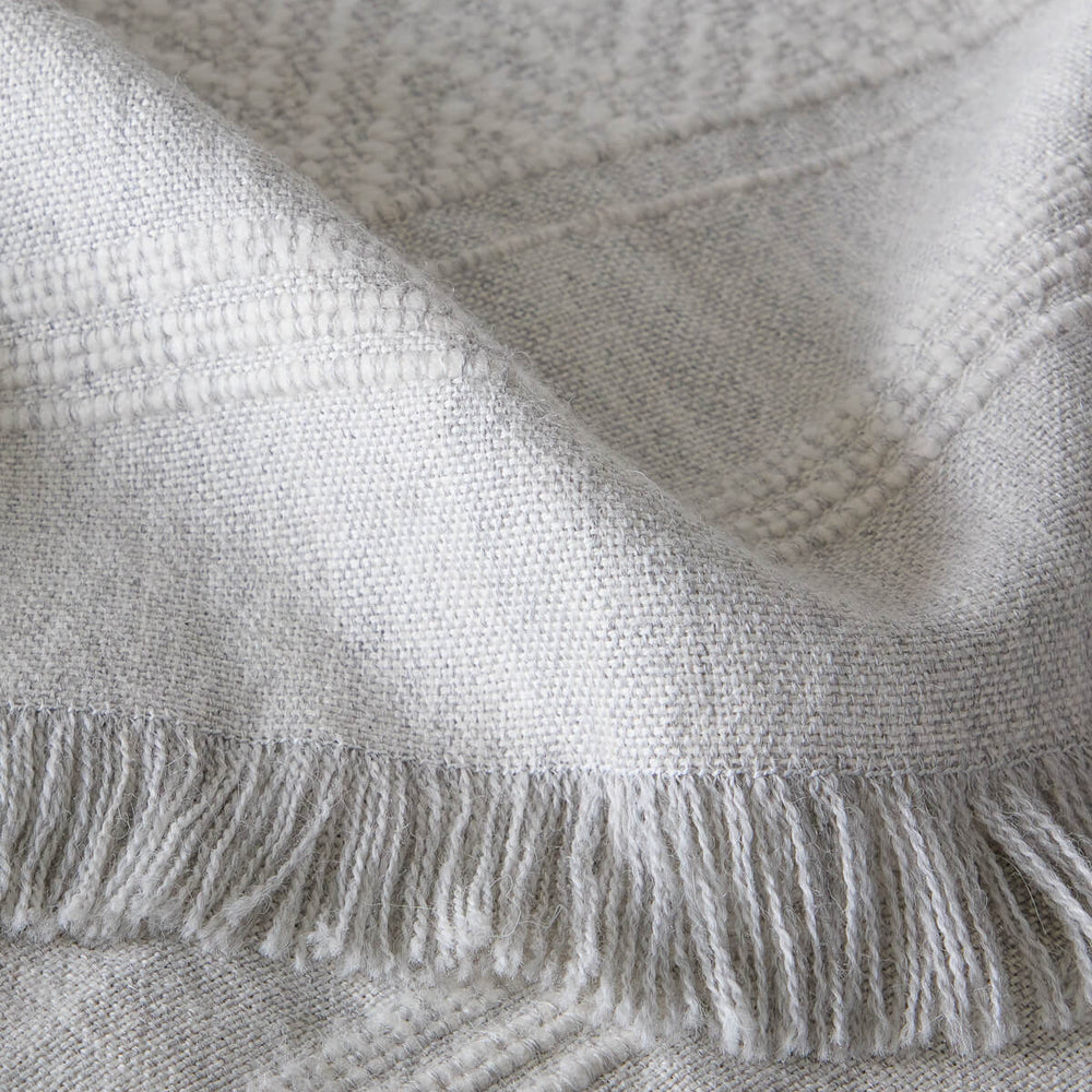 Detail of La Marea super soft baby alpaca blanket by Fairkind handwoven in Peru with textured stripes and fringe.