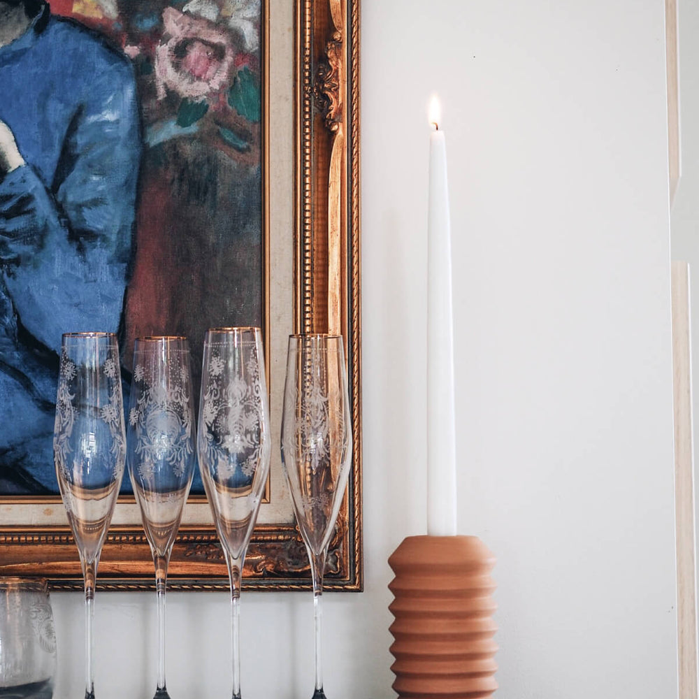 
                  
                    Totem-style terracotta candle holder next to champagne classes on dining room sideboard. Photo via @hello.haveaseat
                  
                
