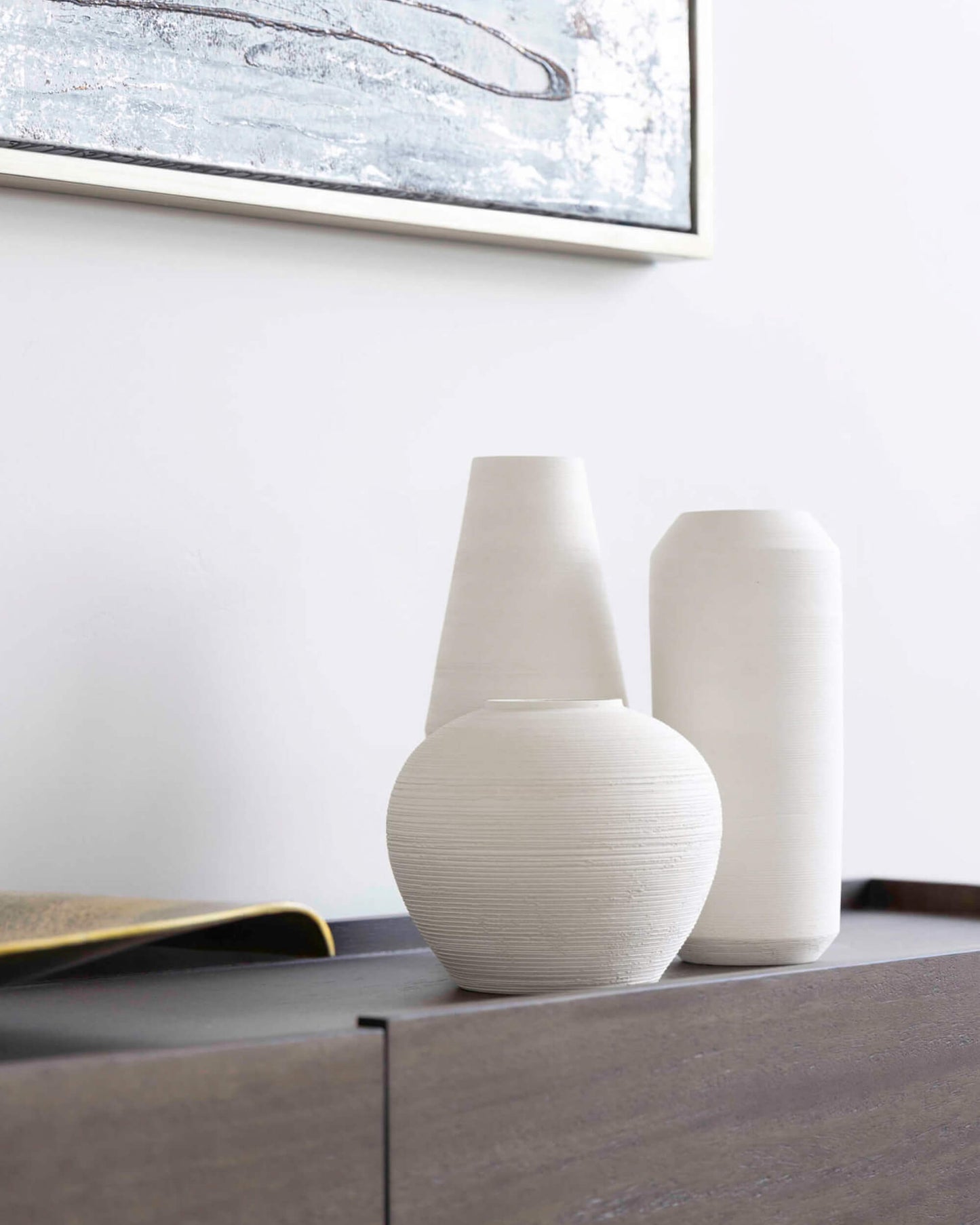 
                  
                    Fairkind's Zarina Vases on a black side table against a white textured wall. Handmade by master ceramists in Morocco.
                  
                