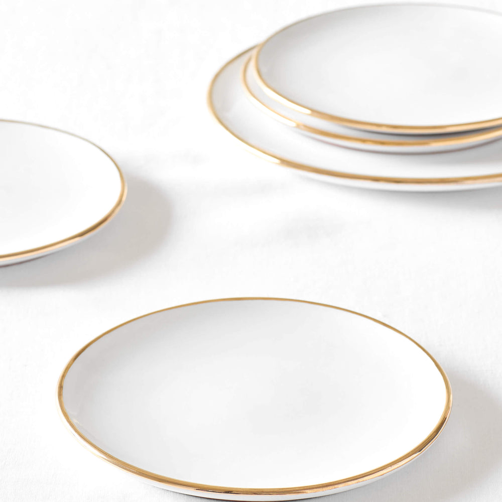 
                  
                    White ceramic salad plate with 18k gold edge on white background. Fez Dinnerware by Fairkind.
                  
                