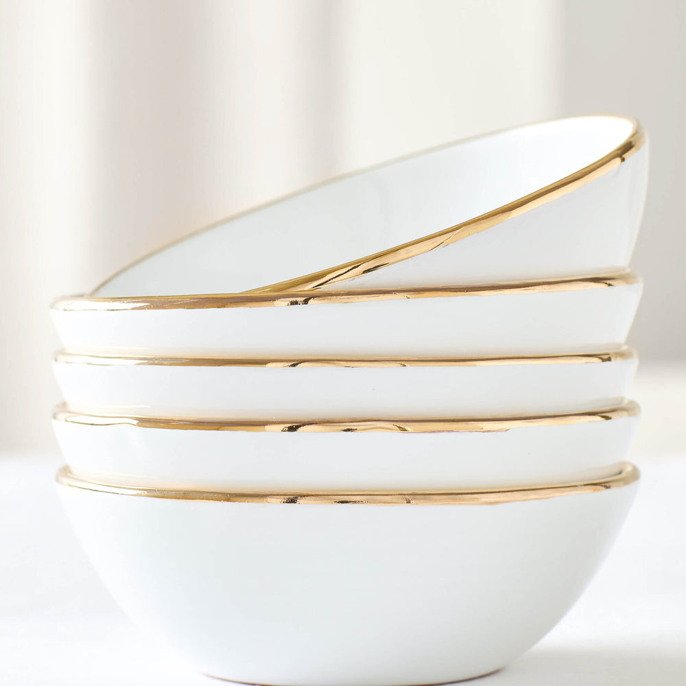 
                  
                    White ceramic soup bowls with 18k gold-rimmed edge stacked against white background. Fez Dinnerware by Fairkind.
                  
                