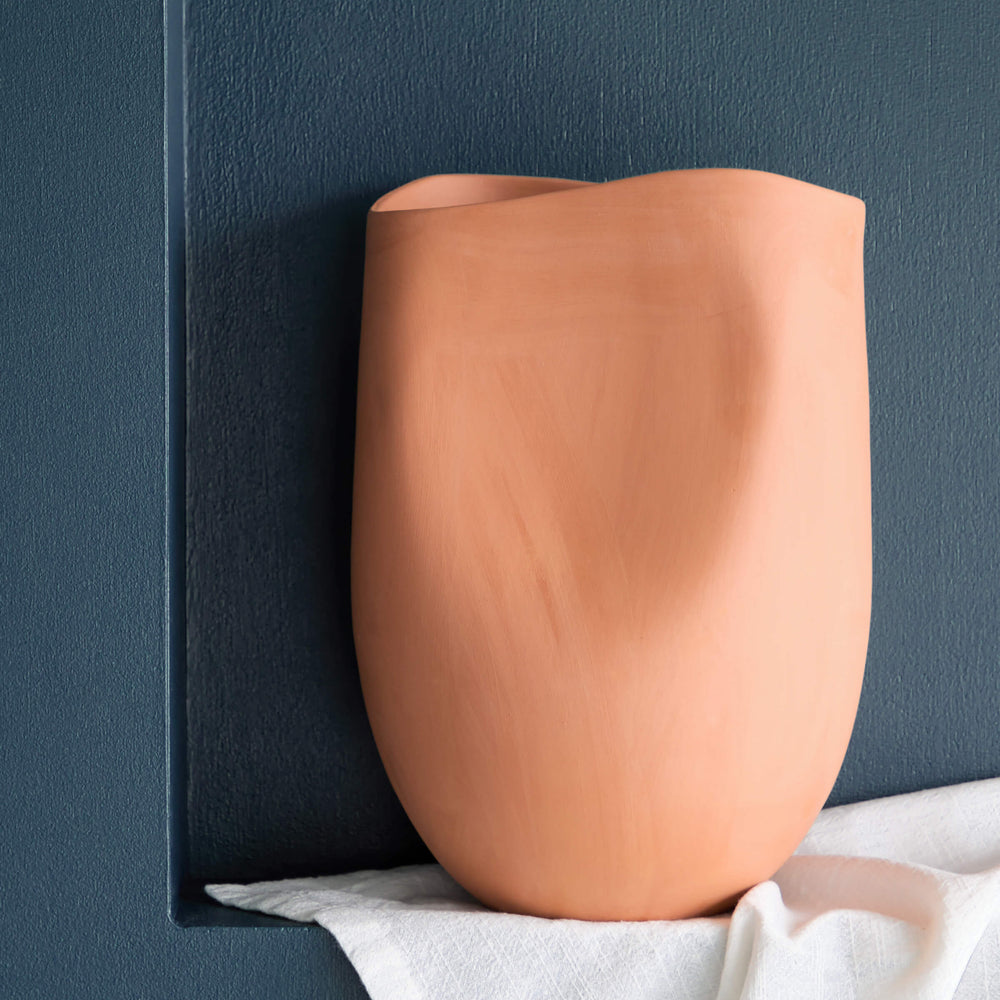 
                  
                    Small Tahj Terracotta Vase styled on blue wall with white tablecloth.
                  
                