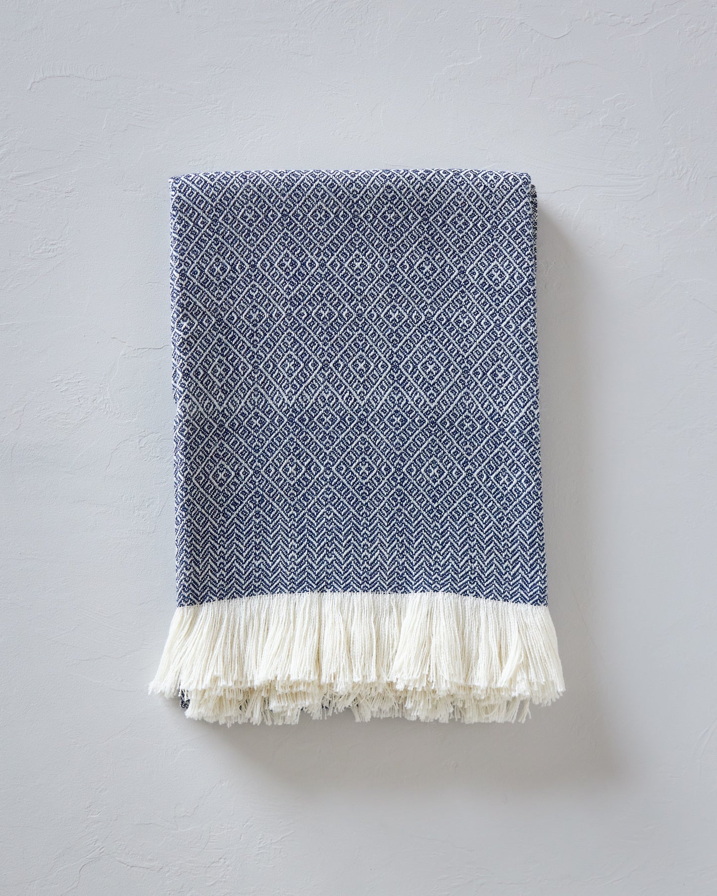 
                  
                    Folded Pacifica navy blue and white luxury baby alpaca throw blanket gift handwoven and hypoallergenic.
                  
                