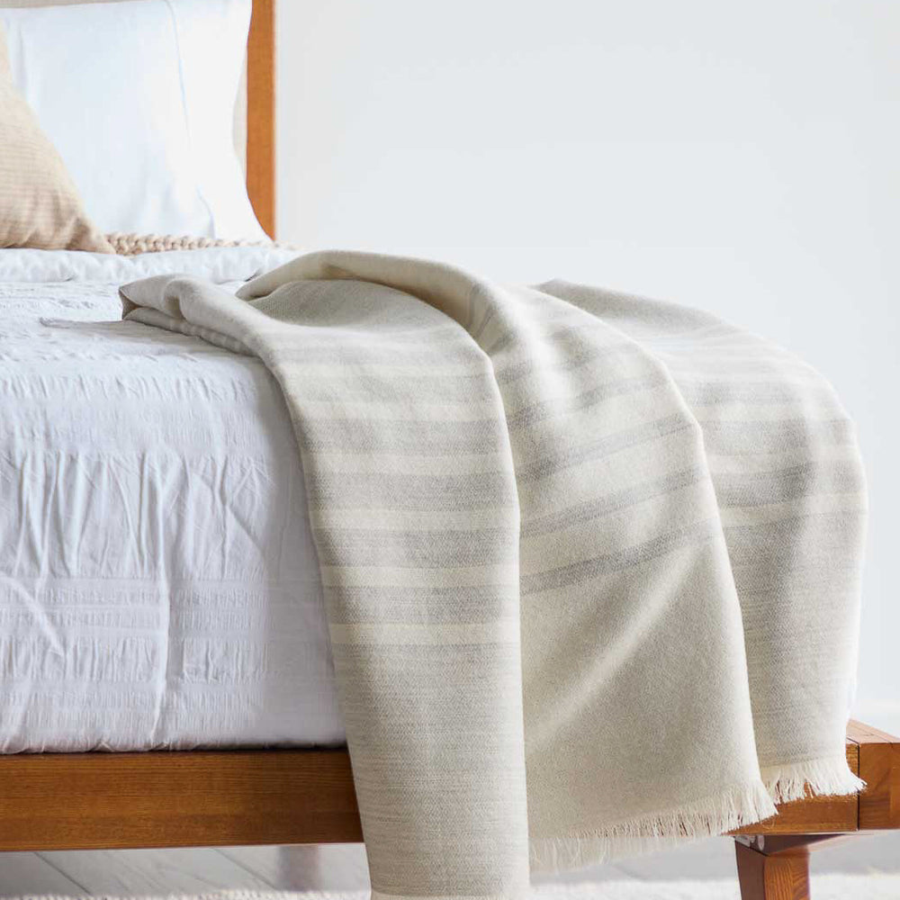 
                  
                    Beautiful luxury gray and white striped Fairkind baby alpaca throw blanket ethically sourced and handmade in Peru.
                  
                