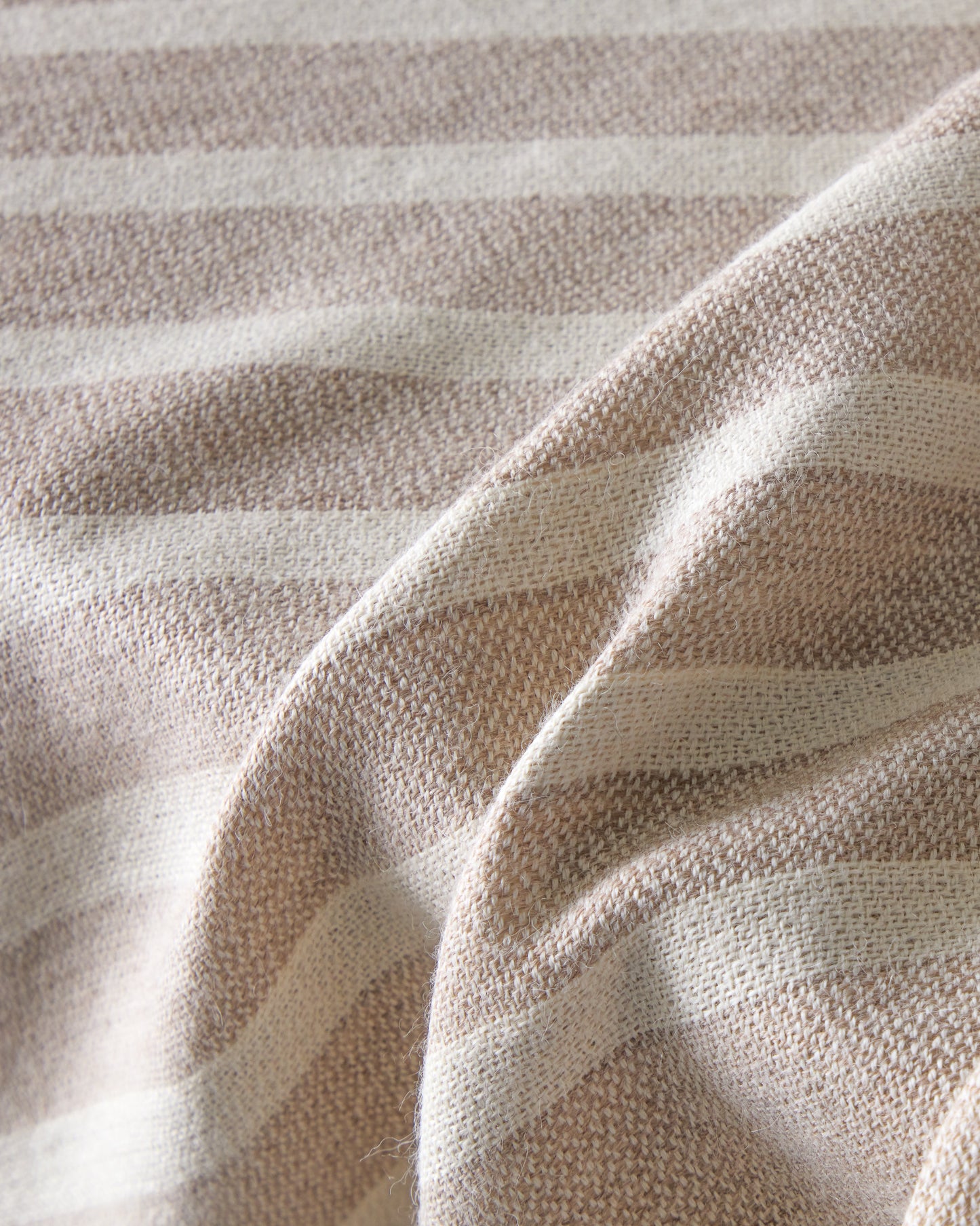Detail of baby alpaca throw blanket sand with white stripes and fringe super soft and warm lightweight alpaca.
