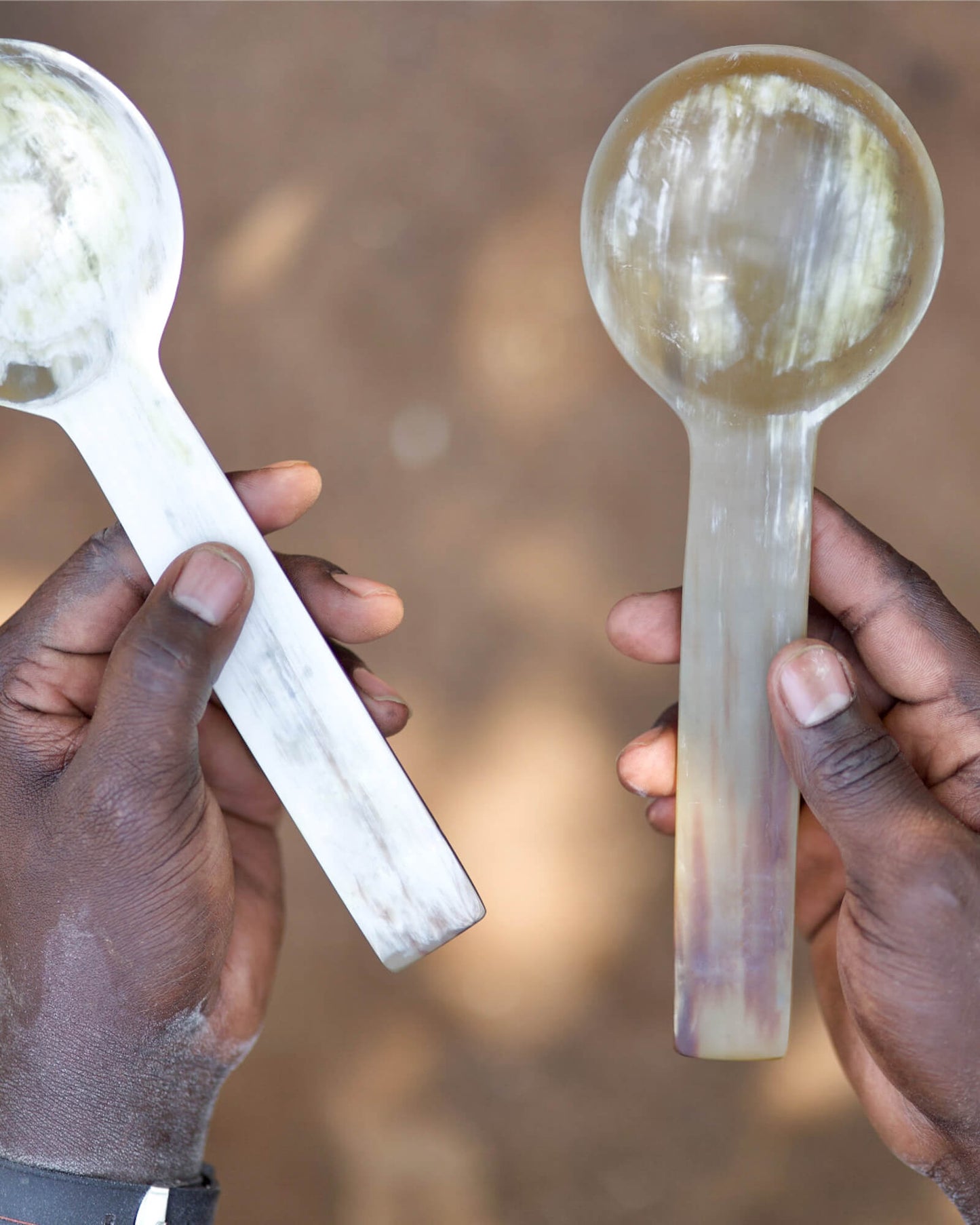 
                  
                    Artisan in Uganda holding Karibu salad spoon set. Handcrafted and fair trade.
                  
                