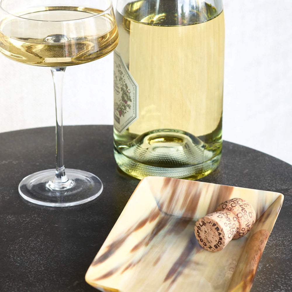 
                  
                    Fairkind Nadira Ankole Horn Tray on side table with champagne.
                  
                