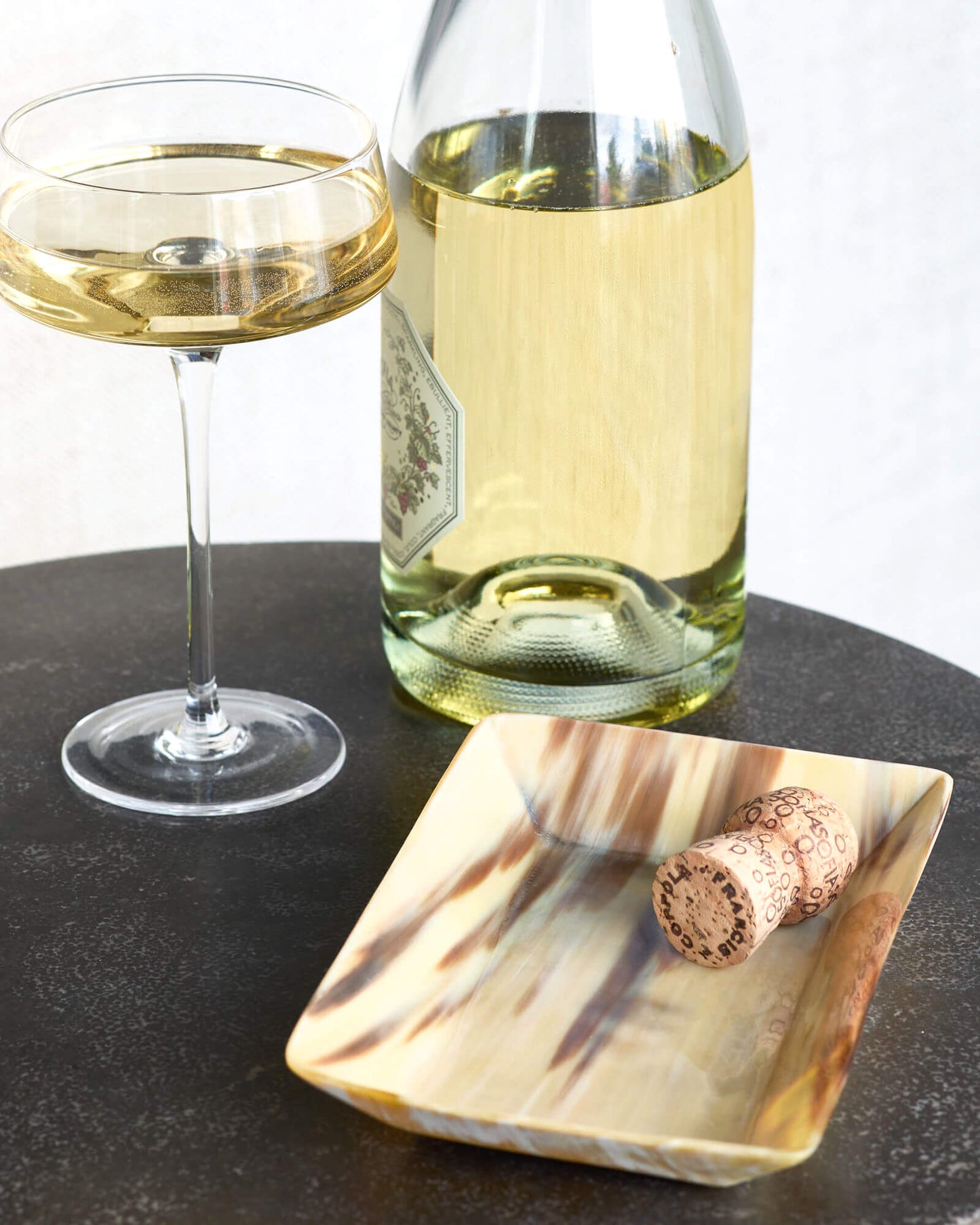 
                  
                    Fairkind Nadira Ankole Horn Tray on side table with champagne.
                  
                
