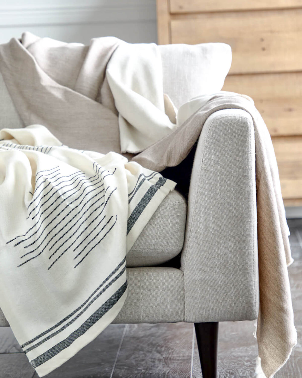 Isleño and Soñando throws draped over modern white couch.