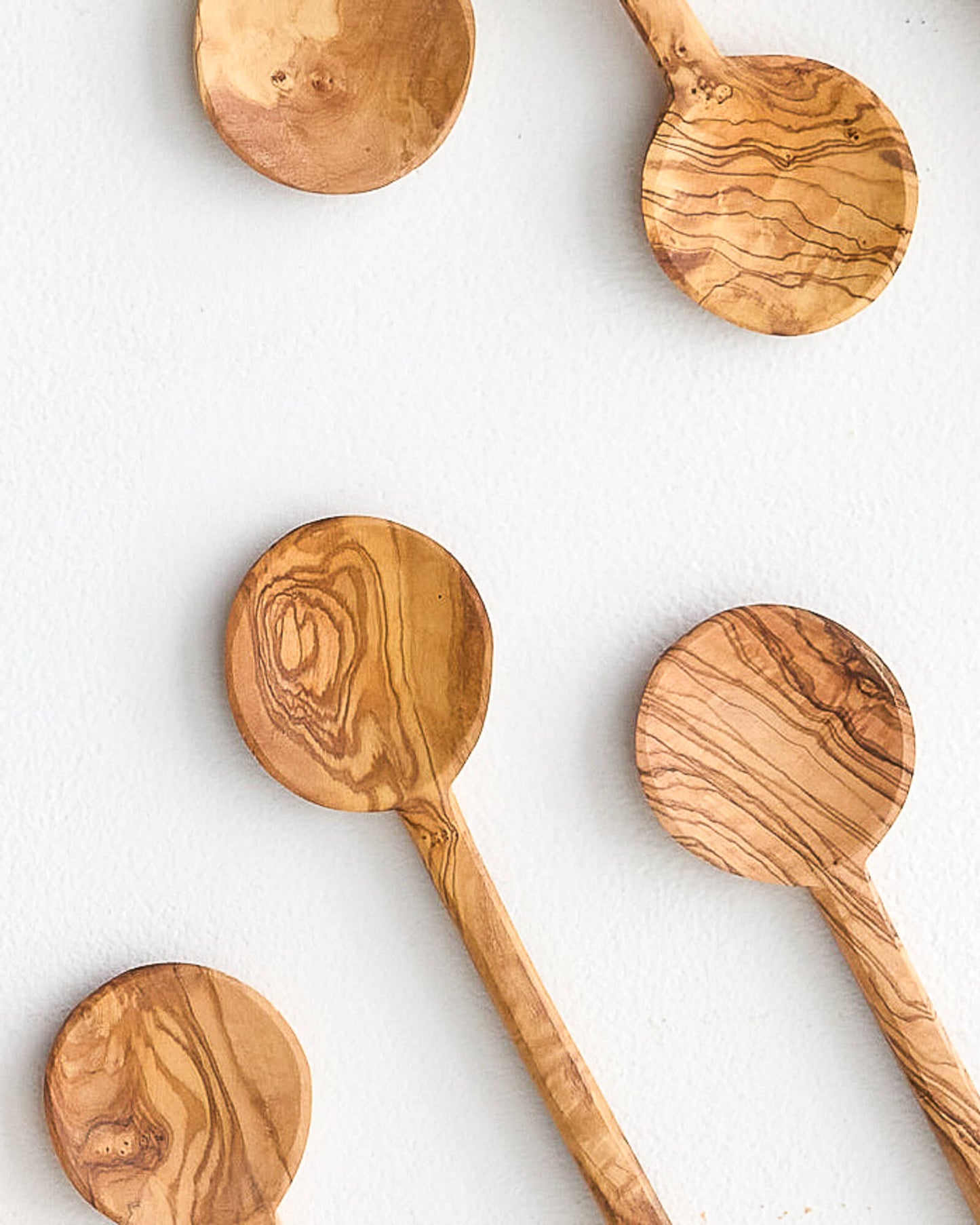 Close up of modern, round olive wood cooking spoons. Handmade in Tunisia.