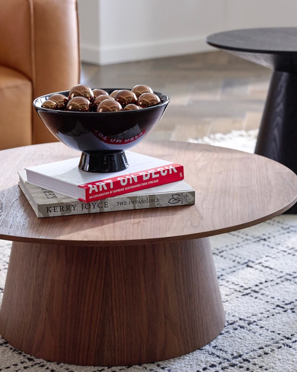 
                  
                    Close up of the Rami Pedestal Bowl in black with metallic decorative balls styled for holiday interiors.
                  
                