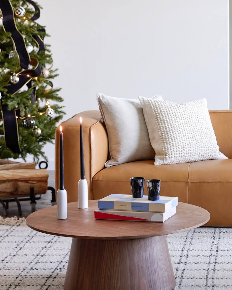 
                  
                    Holiday styled living room with modern round coffee table and handcrafted table decor by Fairkind.
                  
                