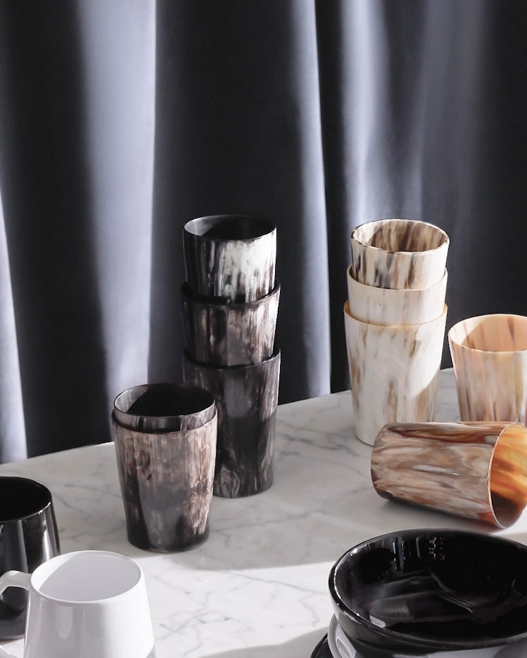Natural handmade horn tumblers against dark velvet backdrop. Holiday tableware and decor by Fairkind.