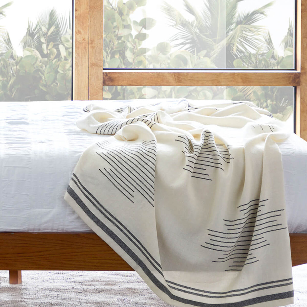 
                  
                    Luxury white and black alpaca throw blanket in modern bedroom.
                  
                