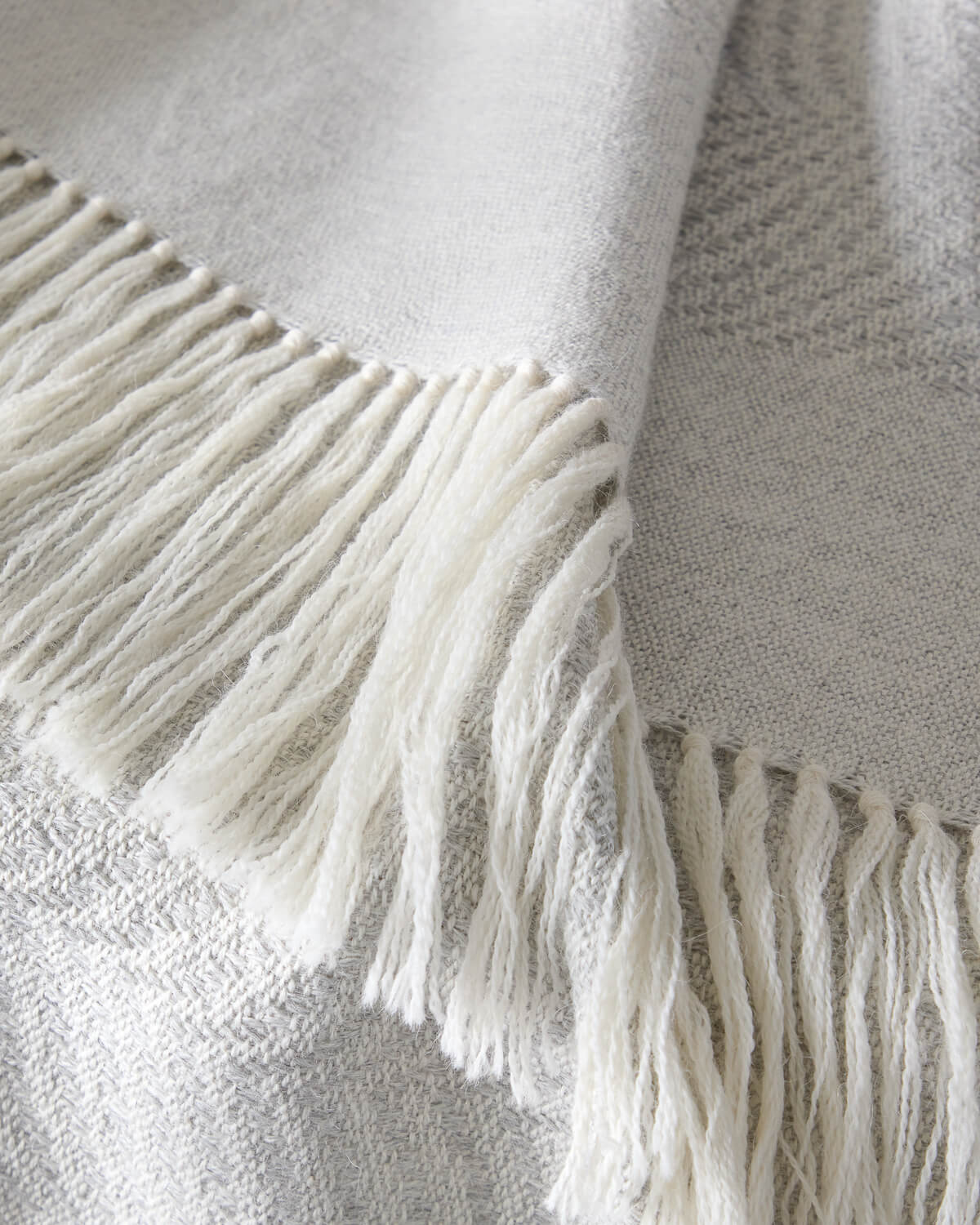 
                  
                    Detail of Fairkind La Loma alpaca throw blanket white fringe super soft and ethically sourced.
                  
                