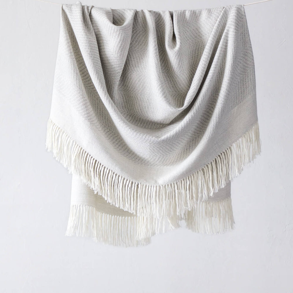 La Loma Fairkind light gray baby alpaca throw with long white fringe made in Peru.