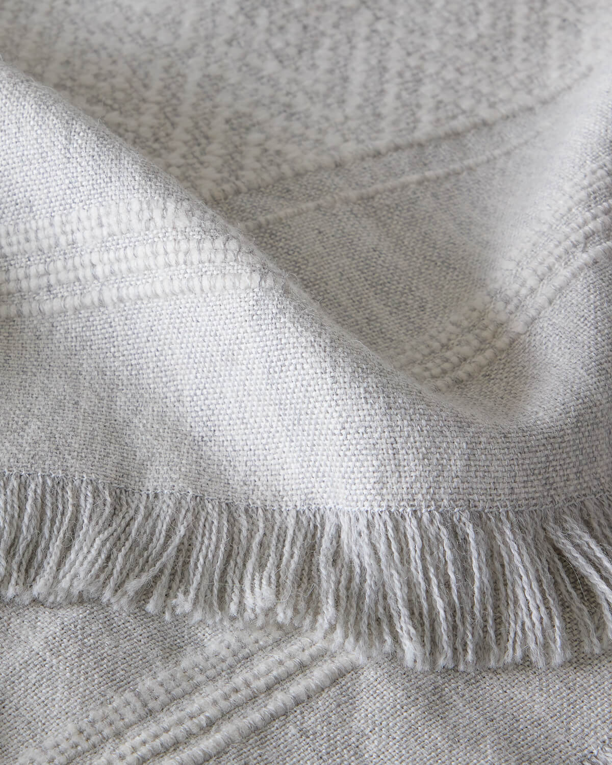 Detail of La Marea super soft baby alpaca blanket by Fairkind handwoven in Peru with textured stripes and fringe.