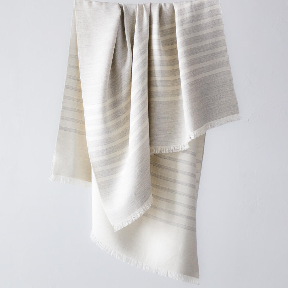 
                  
                    Fairkind Santiago alpaca throw blanket in gray with white stripes and contrasting sides modern design handwoven in Peru.
                  
                