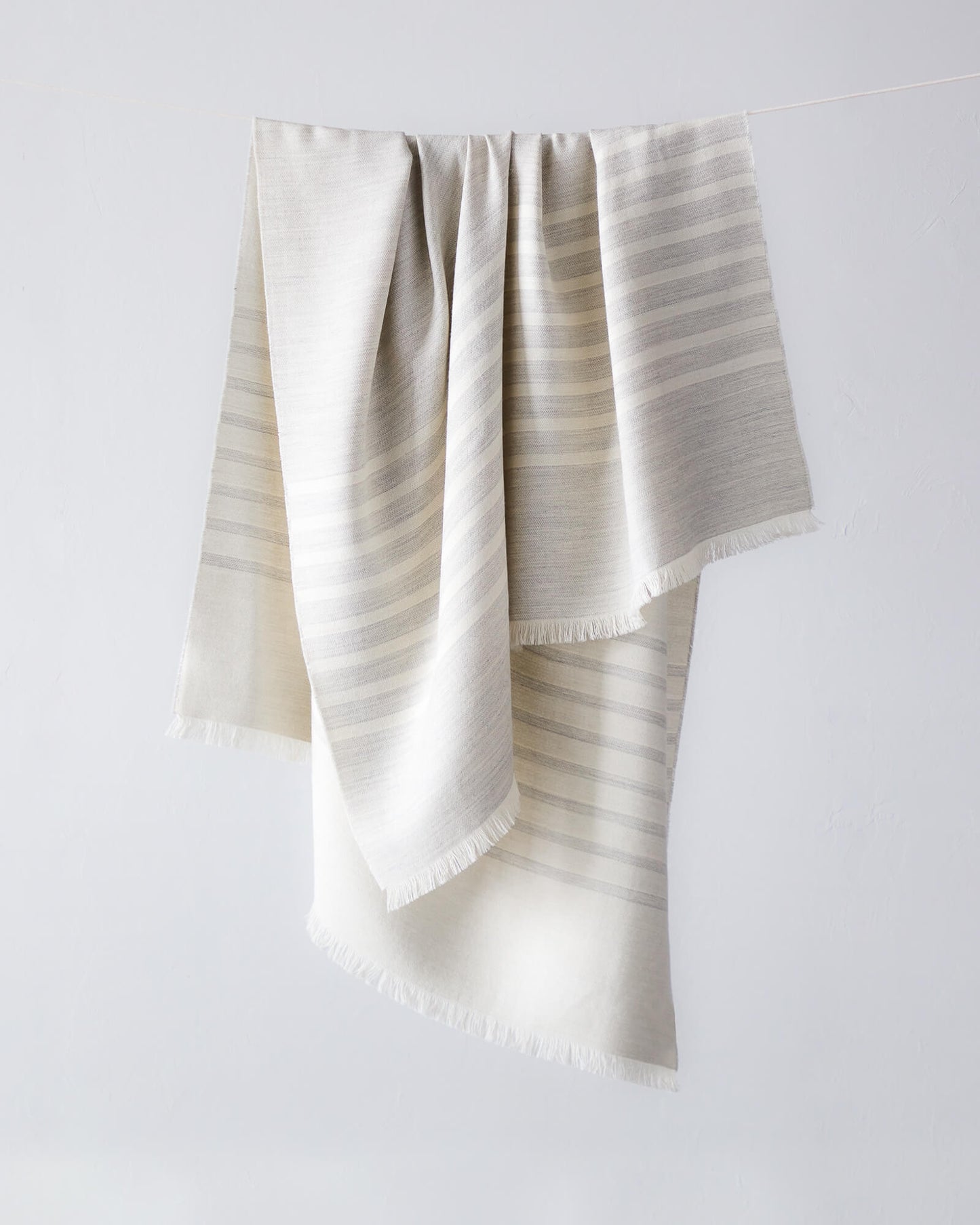 
                  
                    Fairkind Santiago alpaca throw blanket in gray with white stripes and contrasting sides modern design handwoven in Peru.
                  
                