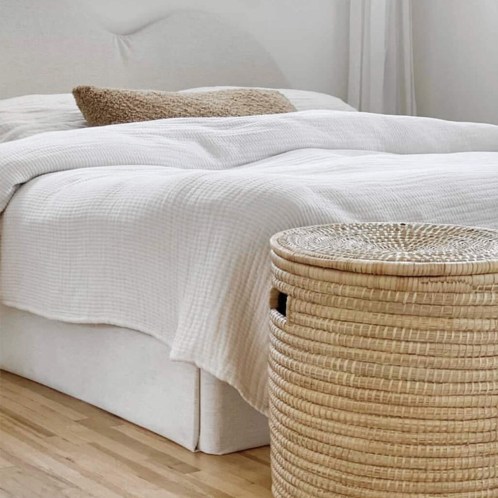 
                  
                    Lidded palm storage basket at the end of a white platform bed. Photo via @farahpro
                  
                