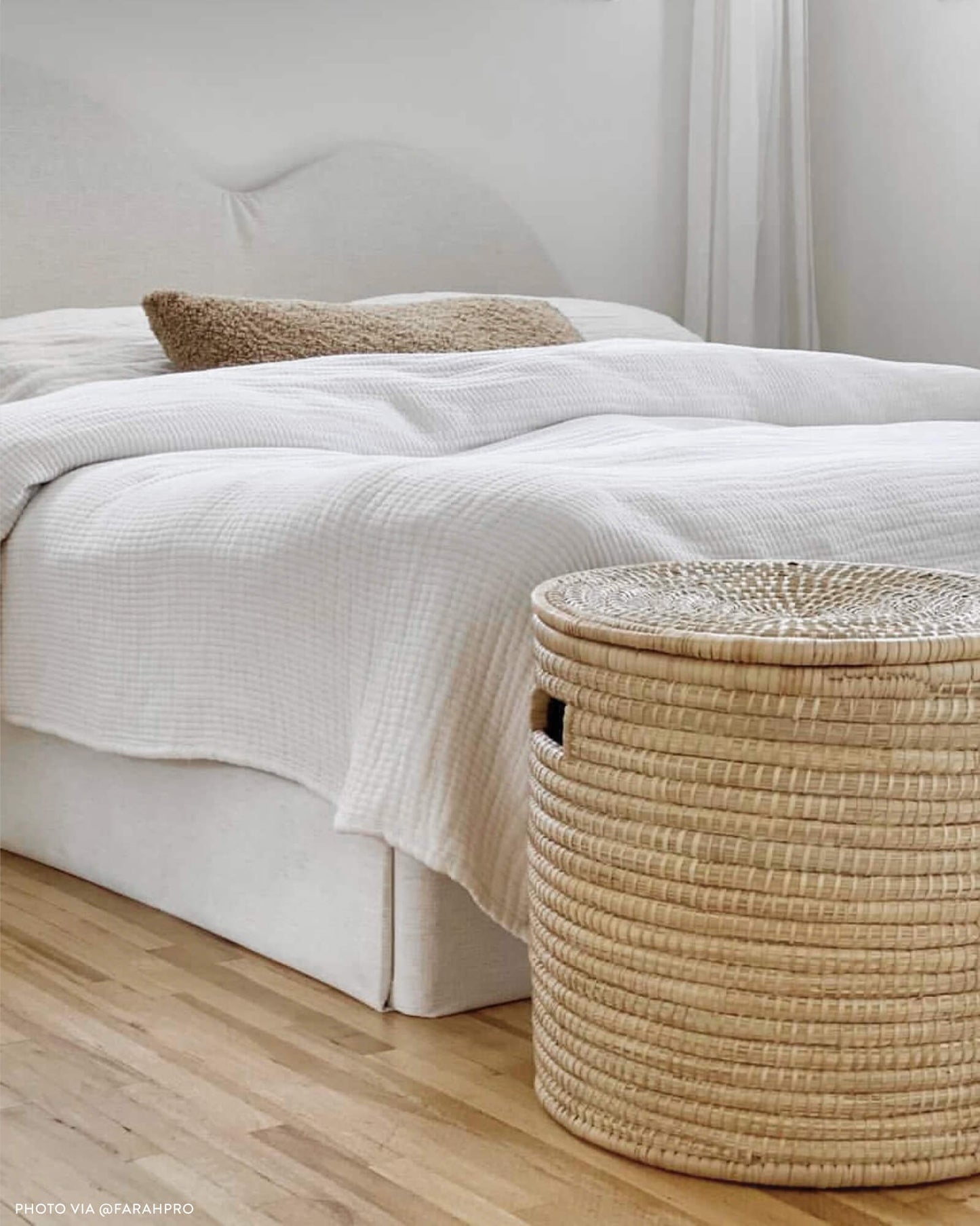 
                  
                    Lidded palm storage basket at the end of a white platform bed. Photo via @farahpro
                  
                