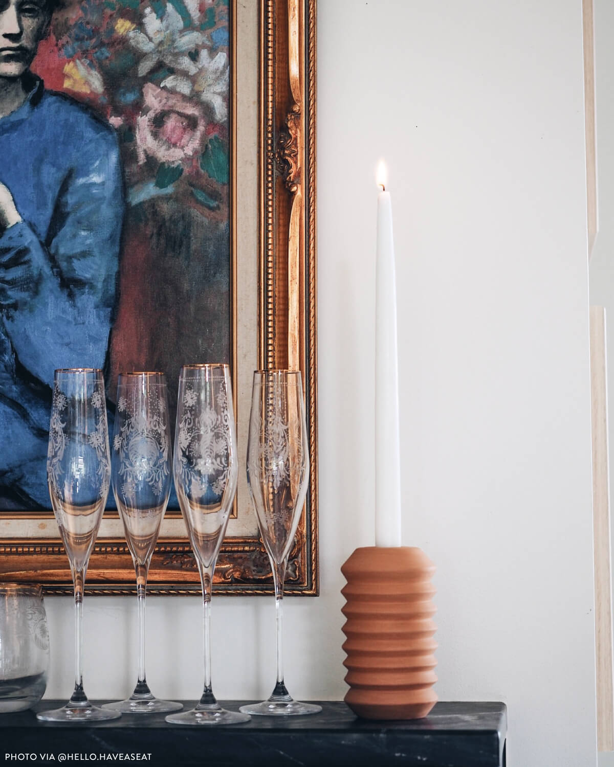 
                  
                    Totem-style terracotta candle holder next to champagne classes on dining room sideboard. Photo via @hello.haveaseat
                  
                