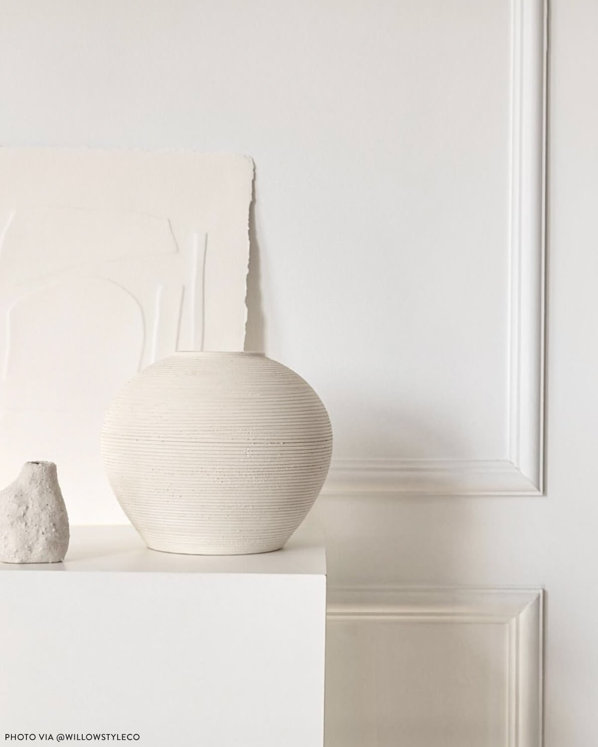 
                  
                    Round textured Zarina vase by Fairkind styled on pedestal in modern living room. Photo via @willowstyleco
                  
                