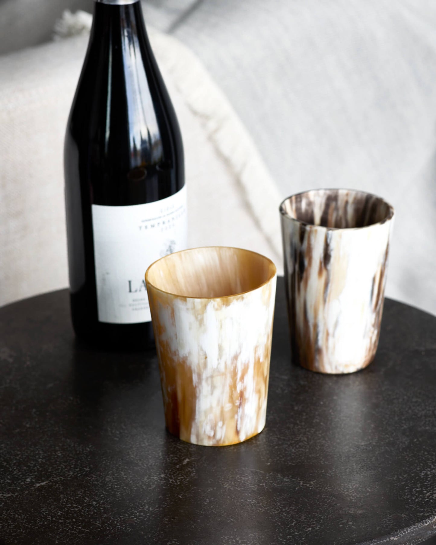 
                  
                    Fairkind's Ankole Horn Collection tumbler set in light with a bottle of wine. Made in Uganda in partnership with Fairkind.
                  
                