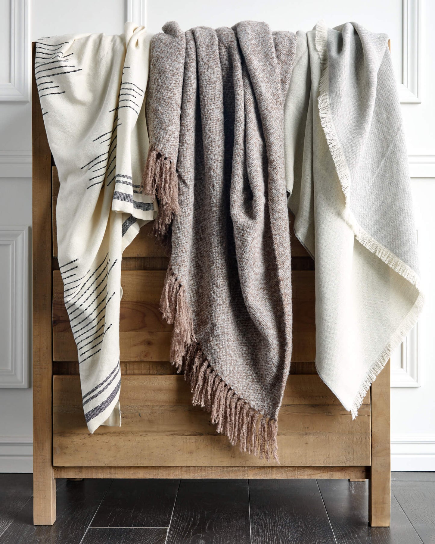 
                  
                    Isleño, La Tierra, and Soñando Alpaca Throw Blankets by Fairkind hanging on dresser.
                  
                