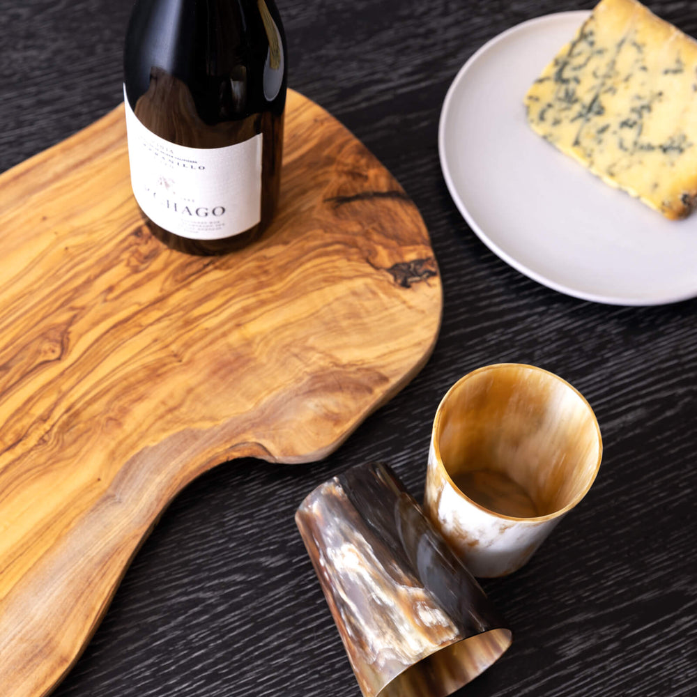 
                  
                    Olive wood cheese board with wine bottle and cheese.
                  
                