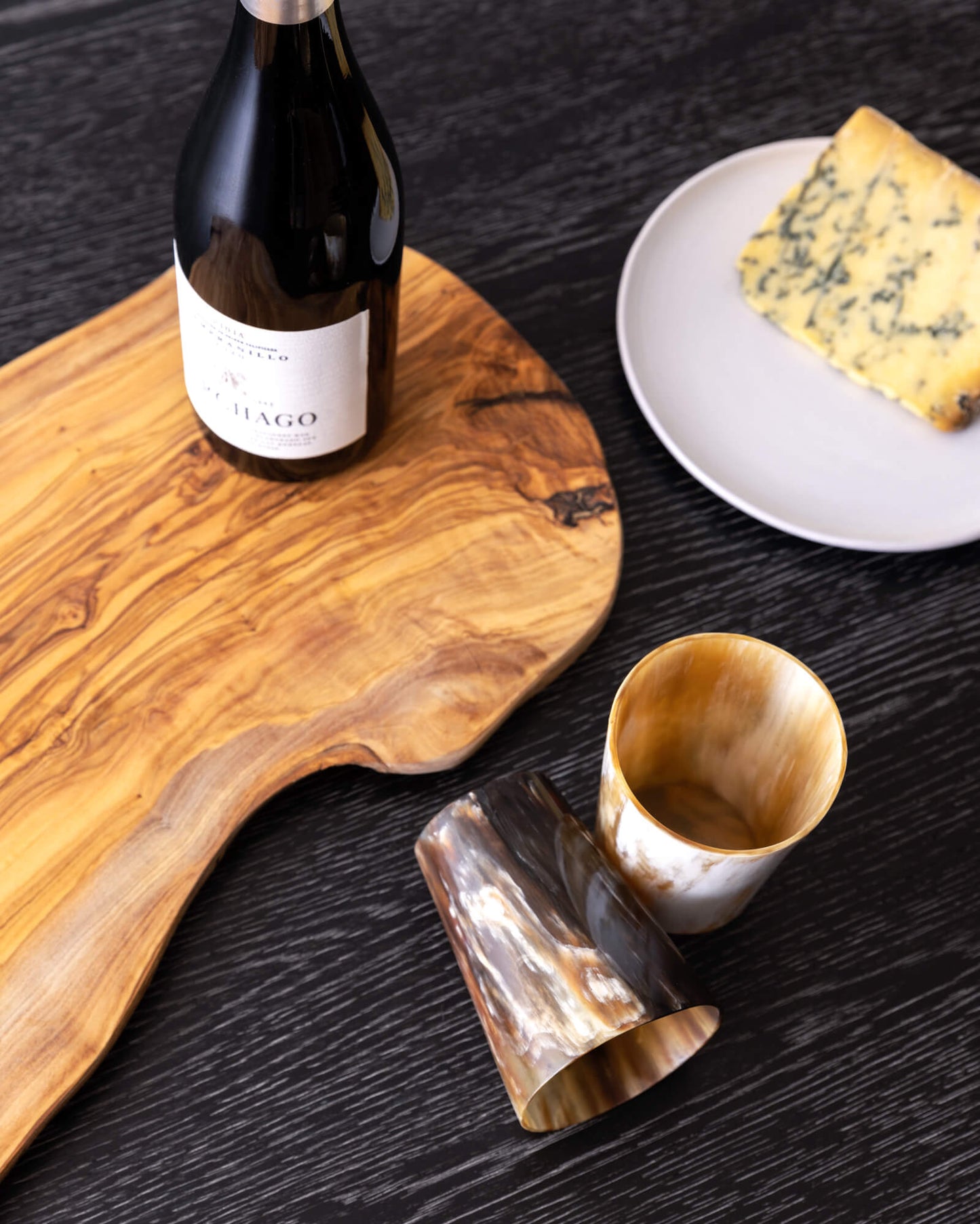 
                  
                    Olive wood cheese board with wine bottle and cheese.
                  
                