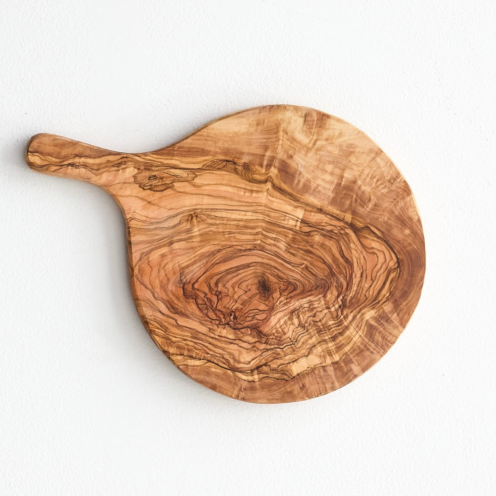 Fairkind's Chebika Bread Board on white background. Round olive wood serving board with handle.