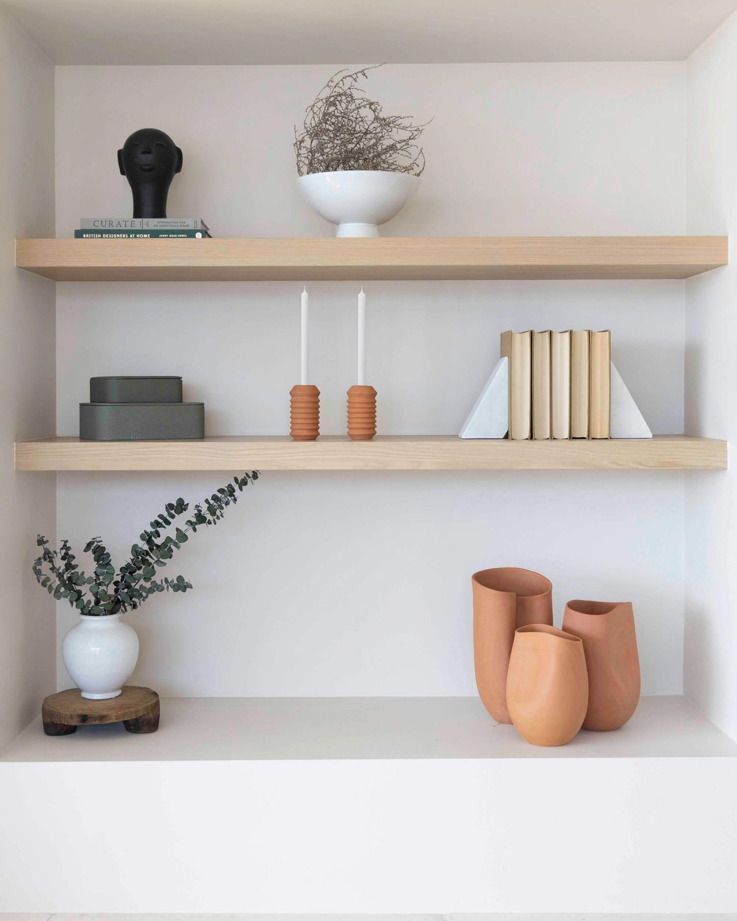 
                  
                    Shelf decor in modern, minimal home. Tahj Terracotta Vases as a set on display.
                  
                