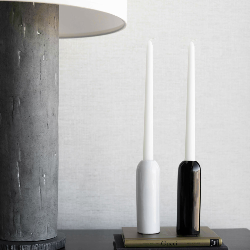 
                  
                    White and black Yasmine taper holders by Fairkind styled on nightstand.
                  
                