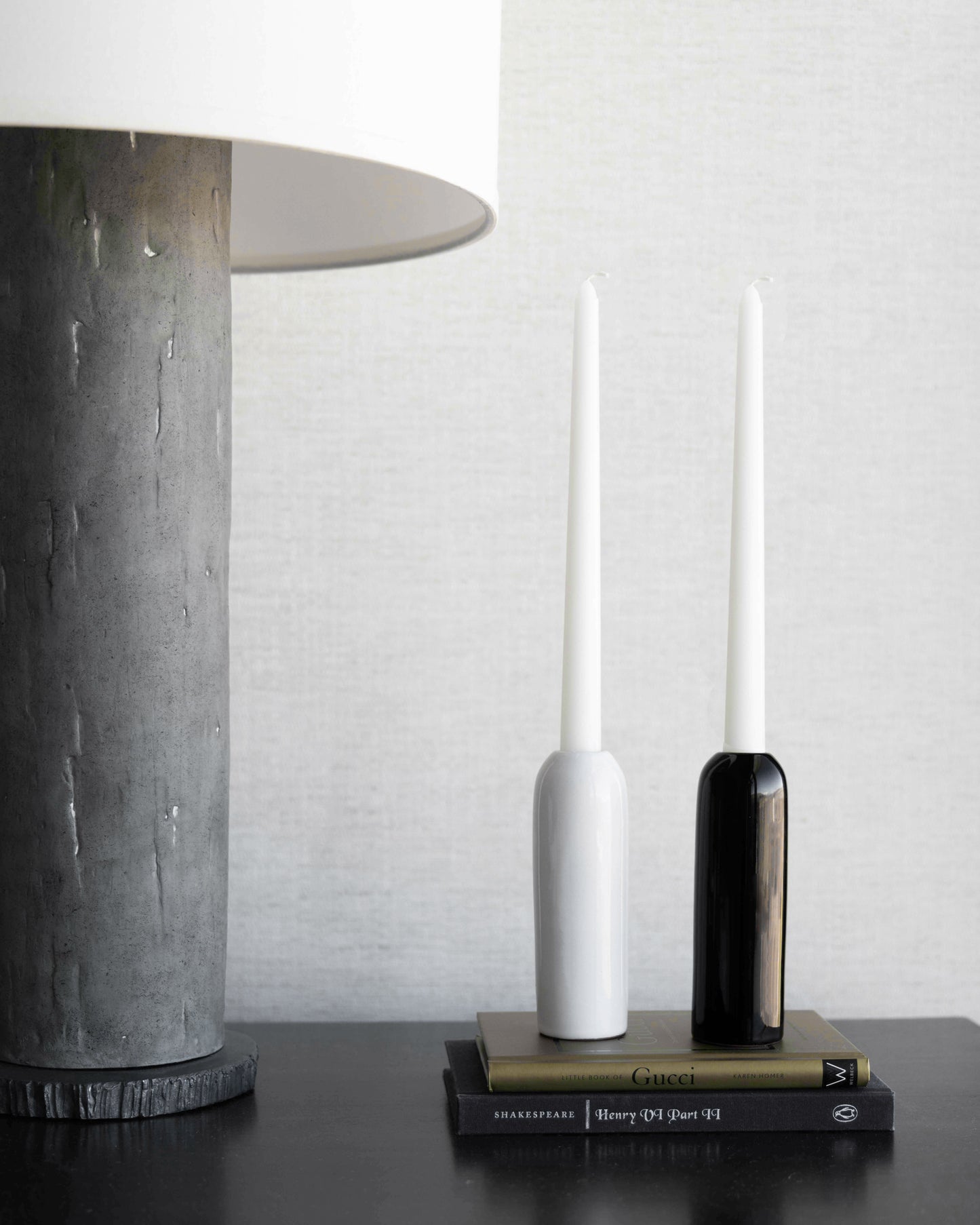 
                  
                    White and black Yasmine taper holders by Fairkind styled on nightstand.
                  
                