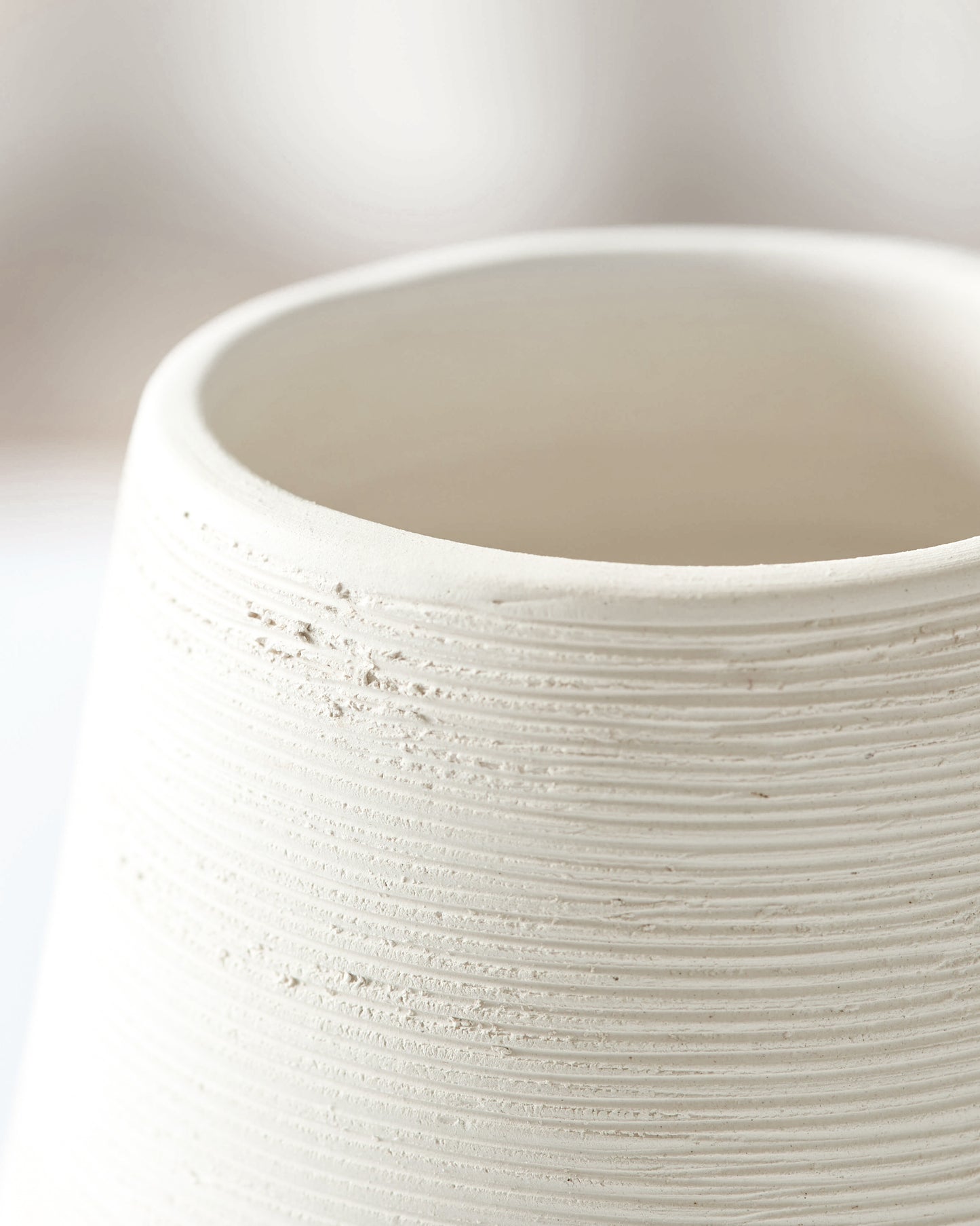 
                  
                    Close-up of Zarina Vase edge detail. Raw white clay with textured bisque finish.
                  
                