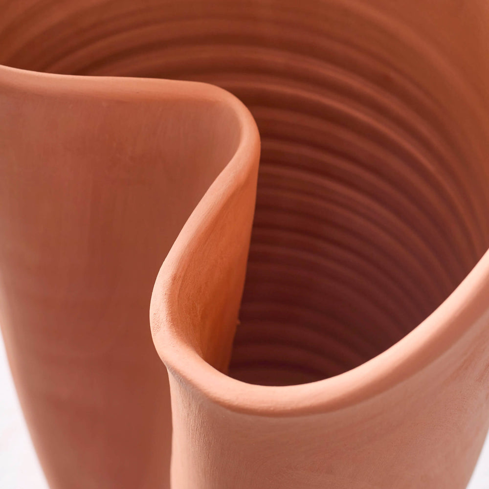
                  
                    Close-up of curved vase edge of sculptural terracotta vase collection.
                  
                