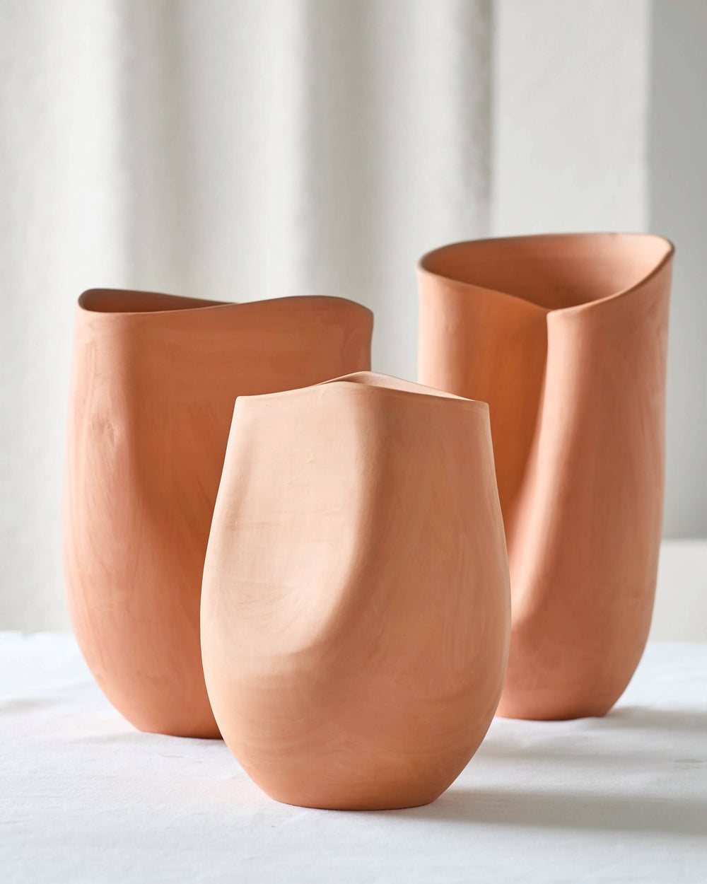 Tahj Terracotta Vases on white table. Handcrafted terracotta clay with sculptural design.