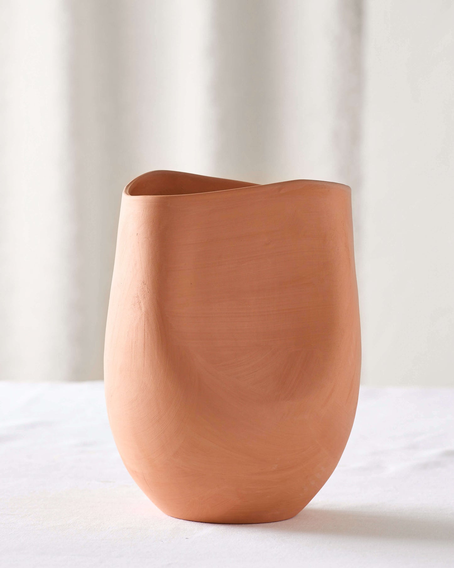 
                  
                    Small Tahj Terracotta Vase on white table. Part of Fairkind's Morocco Collection.
                  
                
