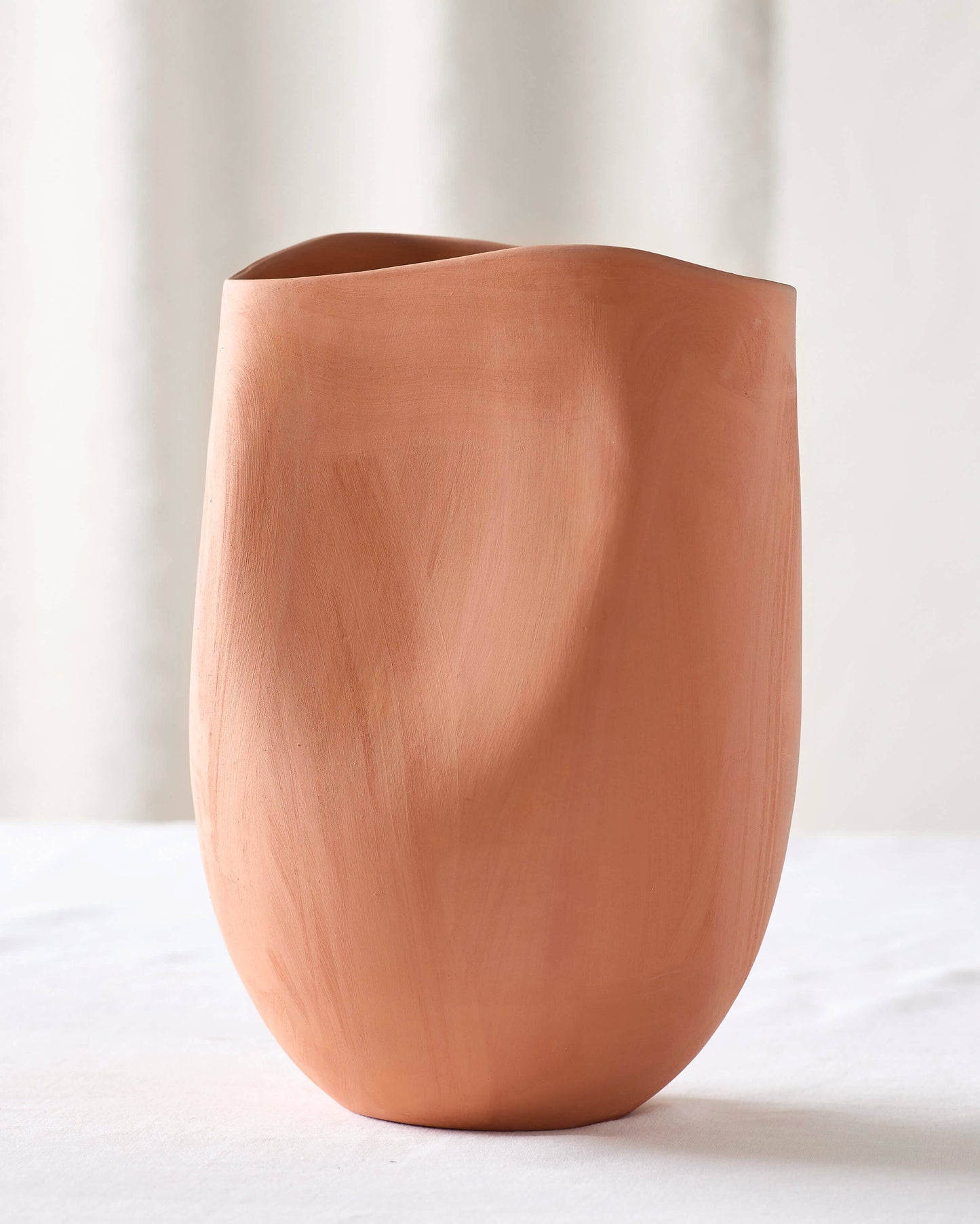 
                  
                    Medium terracotta vase on white table. Handmade in Morocco with locally-sourced clay.
                  
                