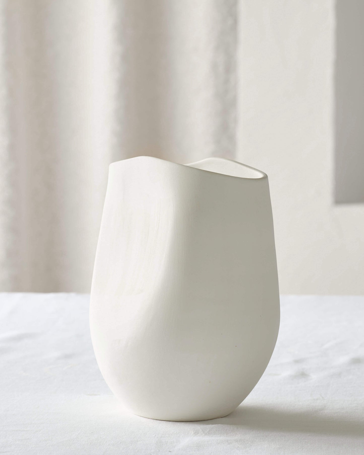 
                  
                    Small Zoya Terracotta Vase on white table. Handcrafted ceramic vase made with raw white clay.
                  
                