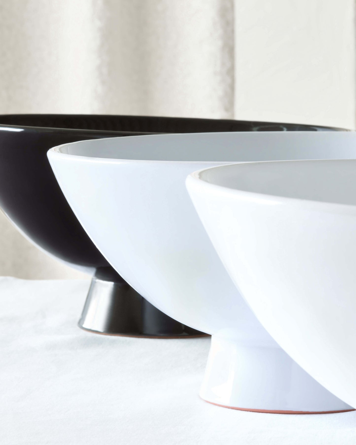 
                  
                    Close-up detail shot of Rami Pedestal Bowls in white, black and gray.
                  
                