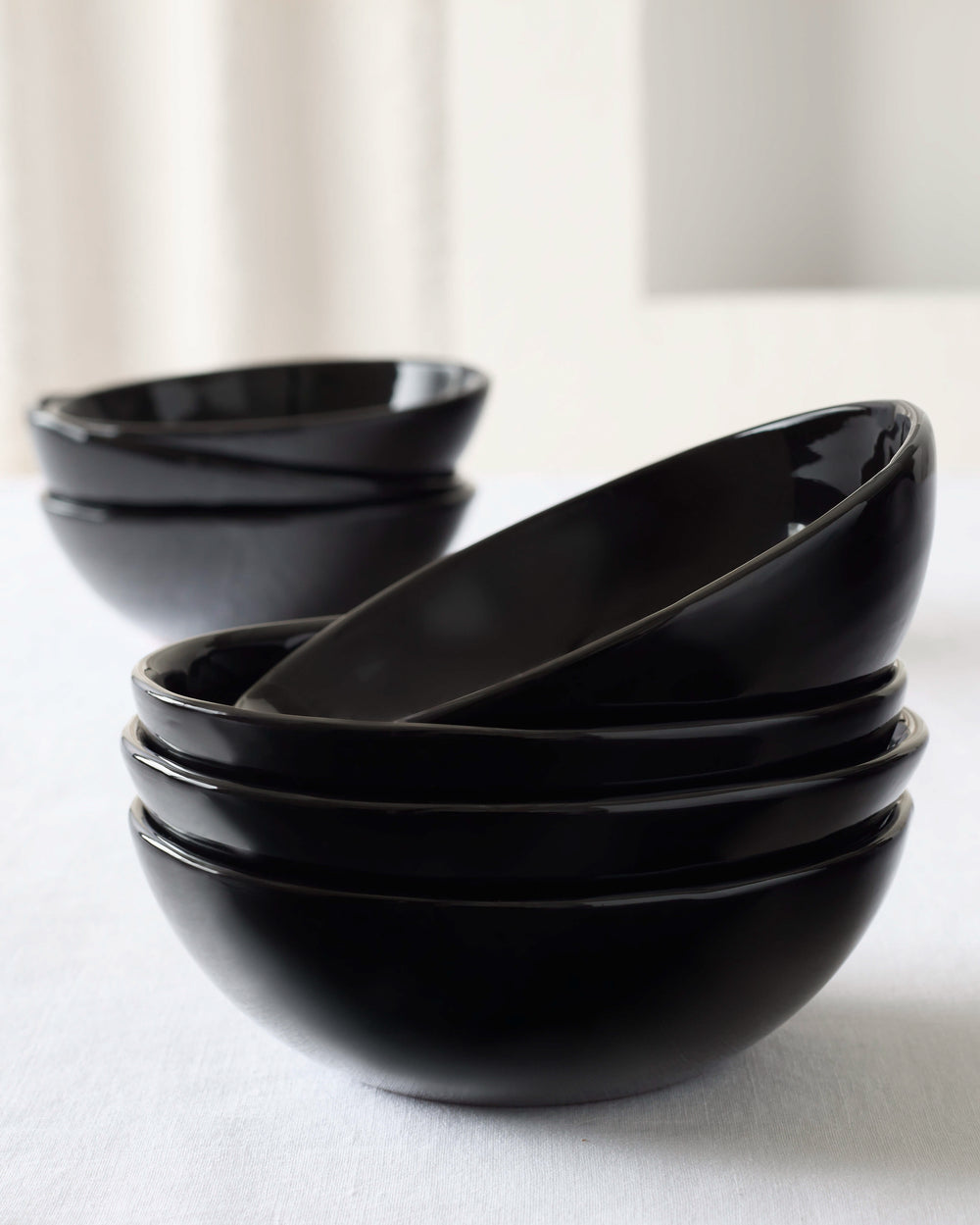 Black Riad Soup Bowls stacked on white table, part of the Morocco Ceramic Collection by Fairkind.