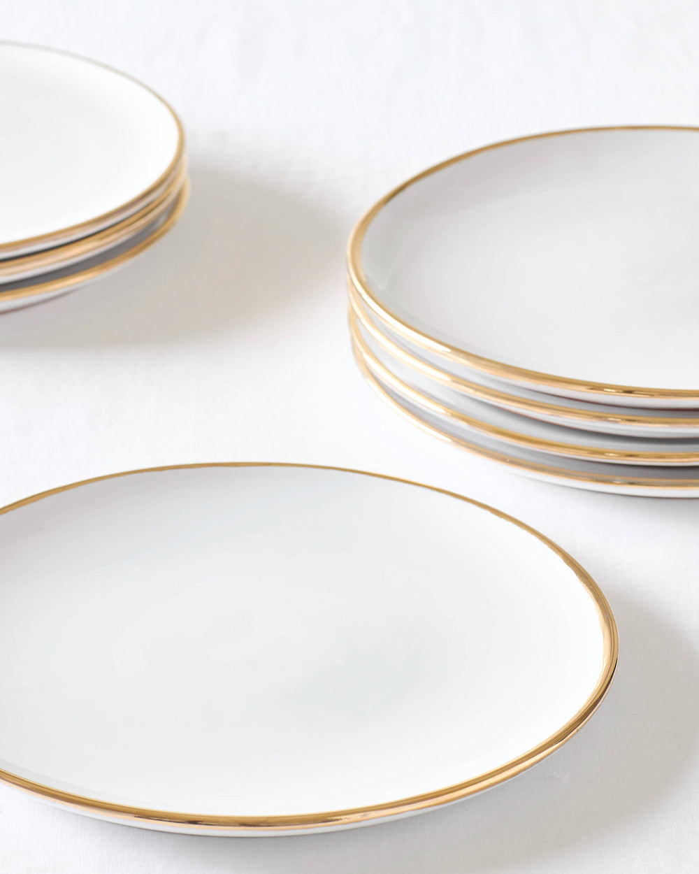 Fairkind's Fez Gold-Rimmed ceramic dinner plate stacked on white table.