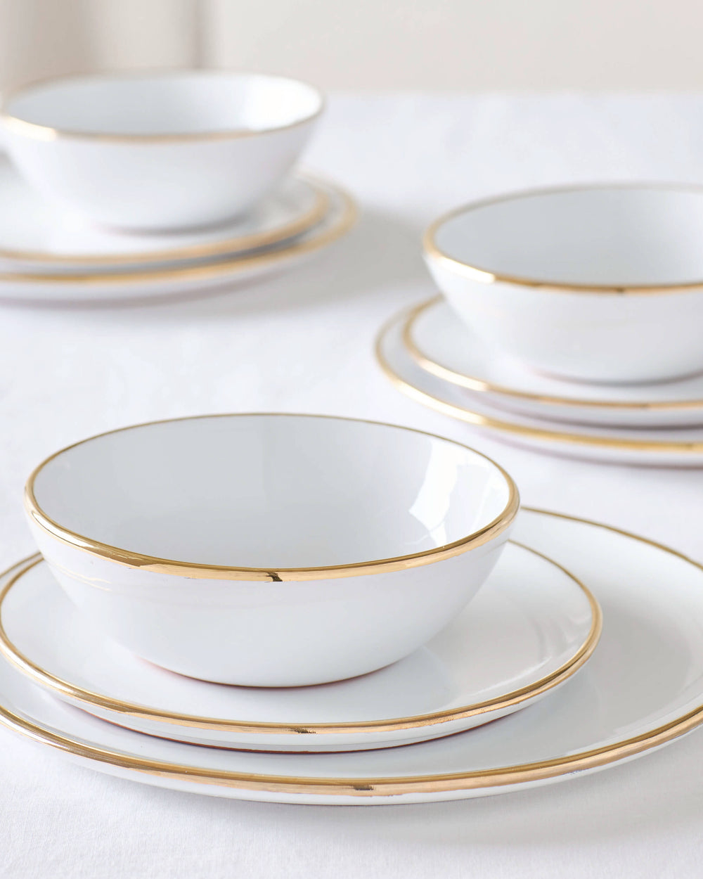 Fez Gold Rimmed Dinnerware sets by Fairkind. White ceramic tableware with 18k gold edge.