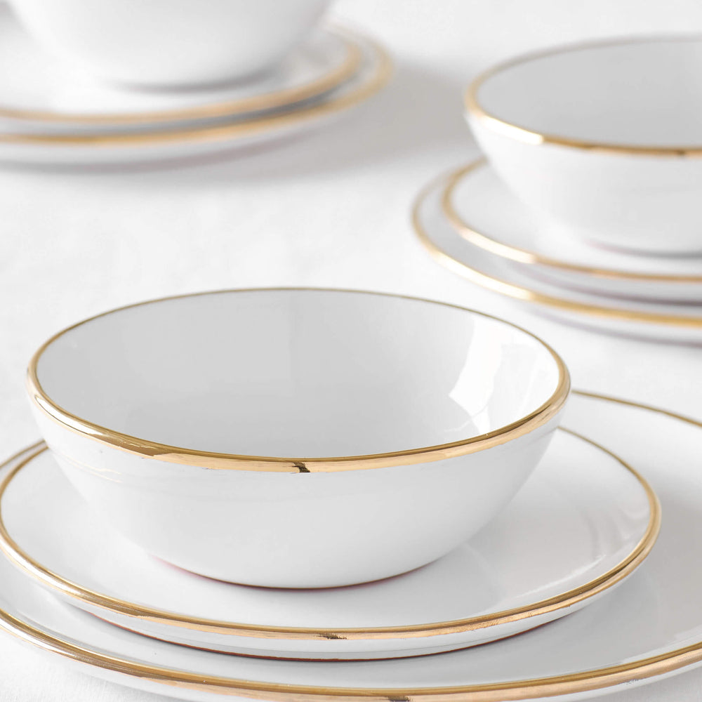 
                  
                    Three sets of Fez Gold-Rimmed dinnerware by Fairkind. Handmade by master ceramists in Morocco.
                  
                
