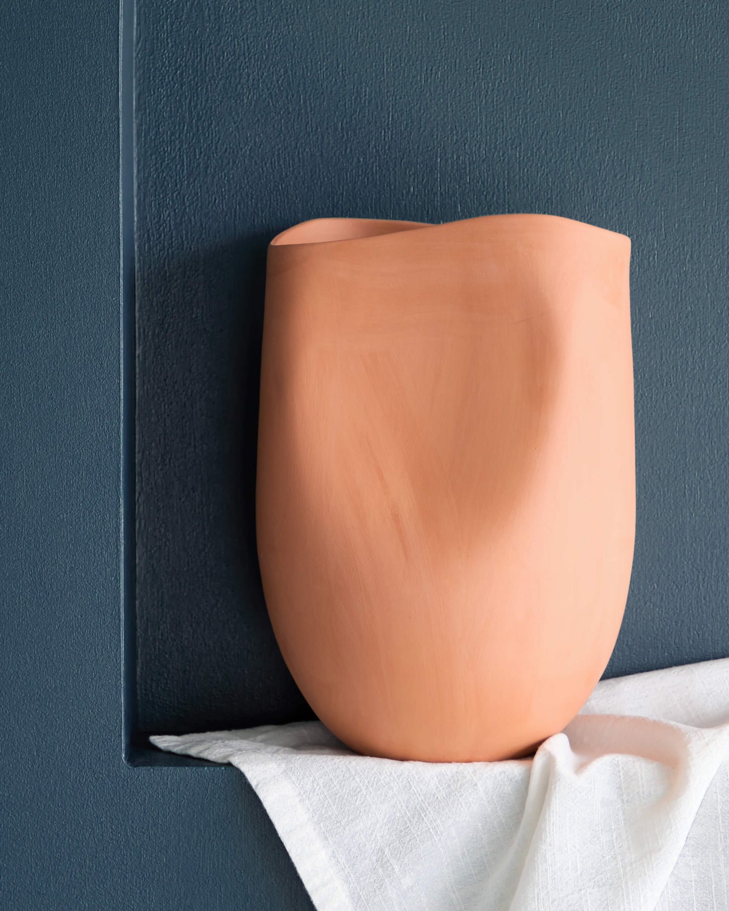 
                  
                    Small Tahj Terracotta Vase styled on blue wall with white tablecloth.
                  
                