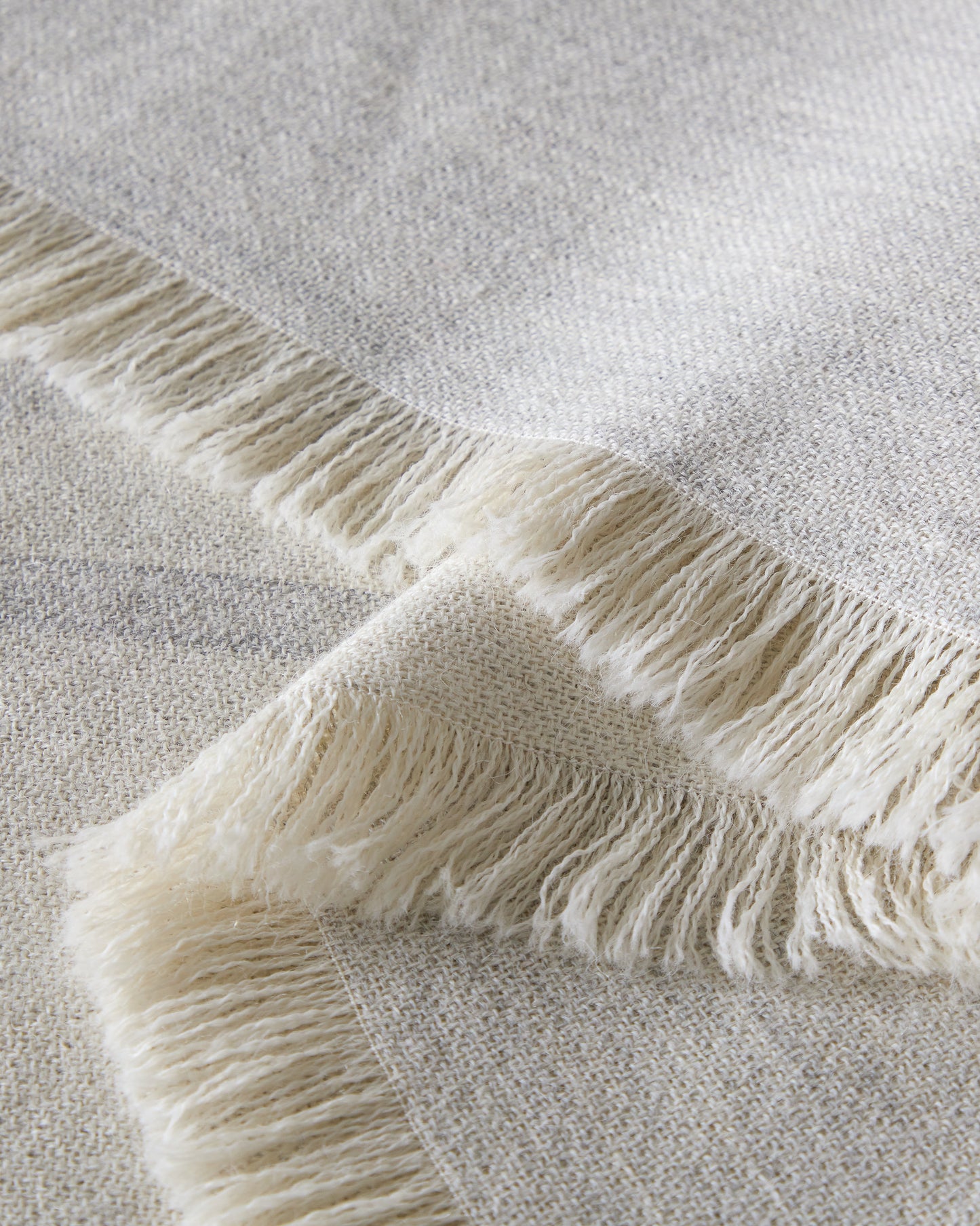 
                  
                    Santiago gray baby alpaca throw blanket detail with soft white fringe handmade in Peru.
                  
                